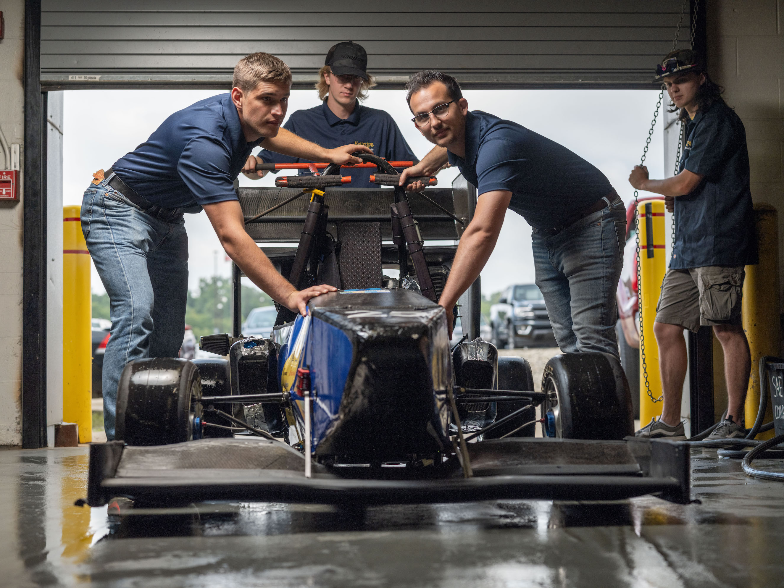 students moving sae formula car into garage