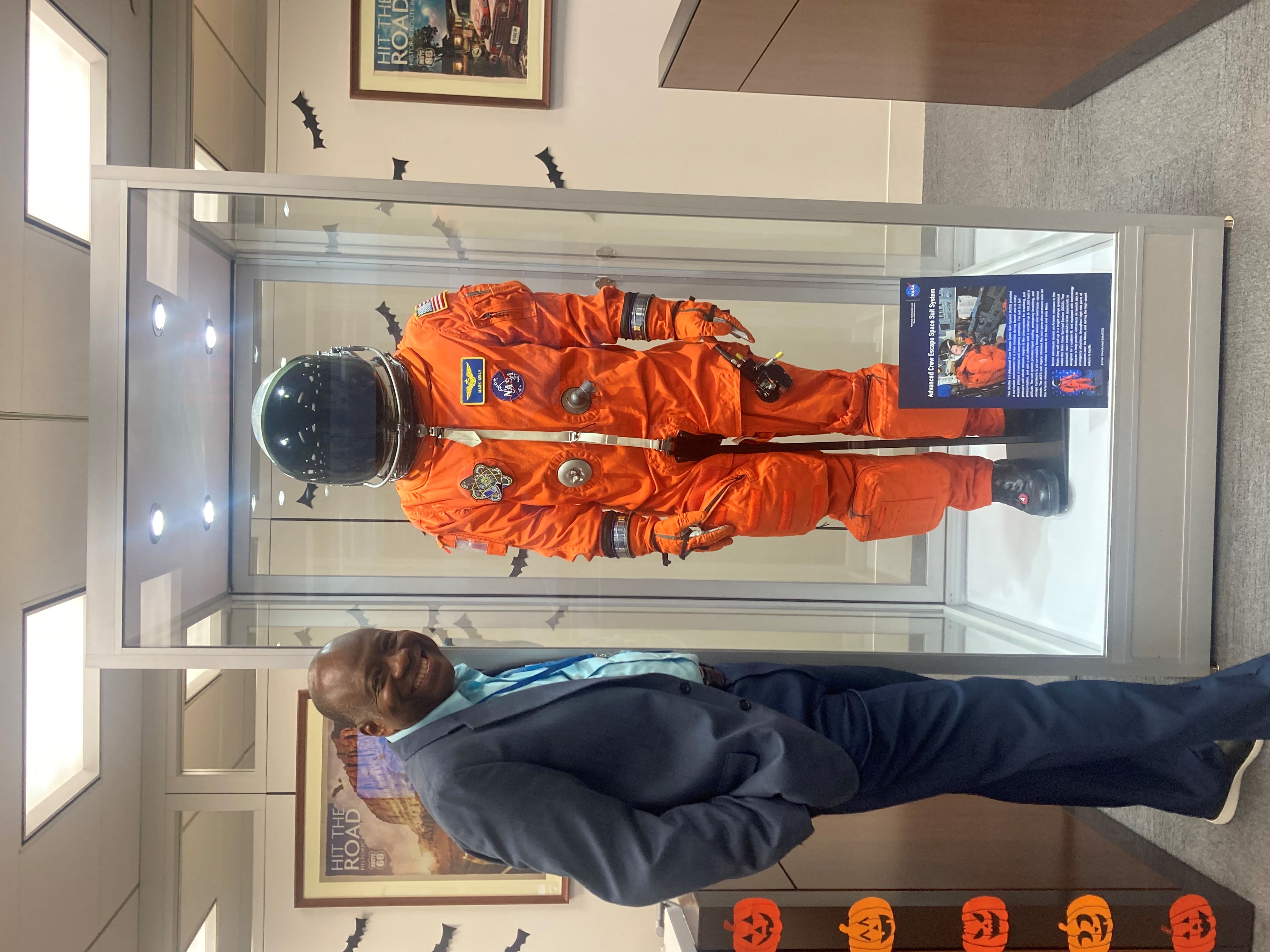 Dr. Berry poses with Sen. Mark Kelly's spacesuit