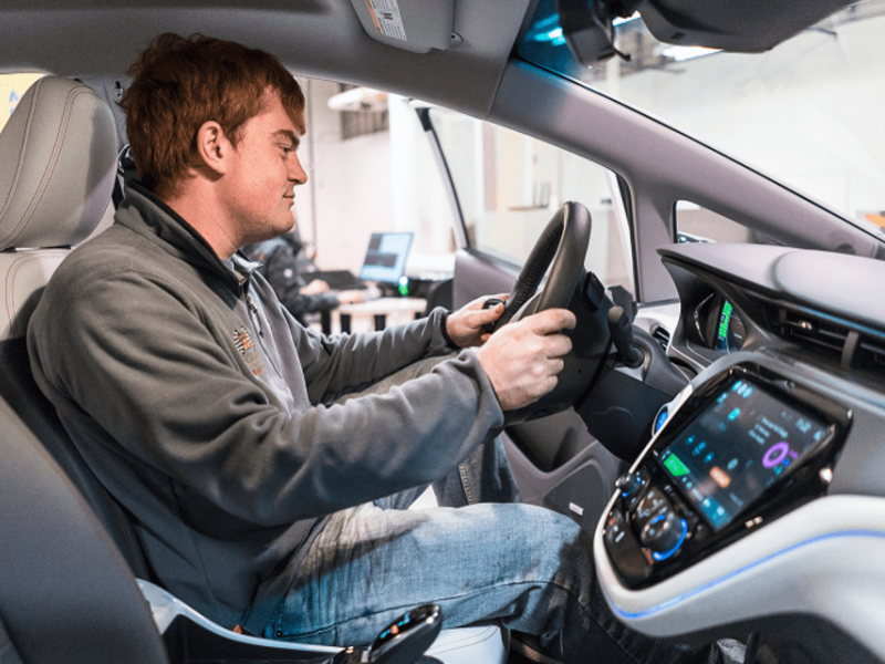 A researcher tests advanced vehicle control systems in Kettering University's Mobile Systems and Vehicle Controls Lab, focusing on driver interaction and system optimization.