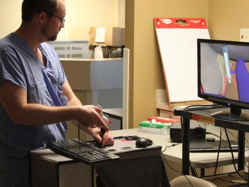 A researcher in Kettering University's Research in Engineering and Collaborative Haptics Lab utilizes a virtual simulation system to study advanced surgical techniques and haptic feedback.