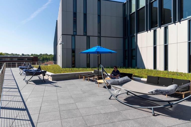 The rooftop terrace of the Learning Commons offers a serene outdoor space for studying and relaxation, featuring hammocks and shaded seating.