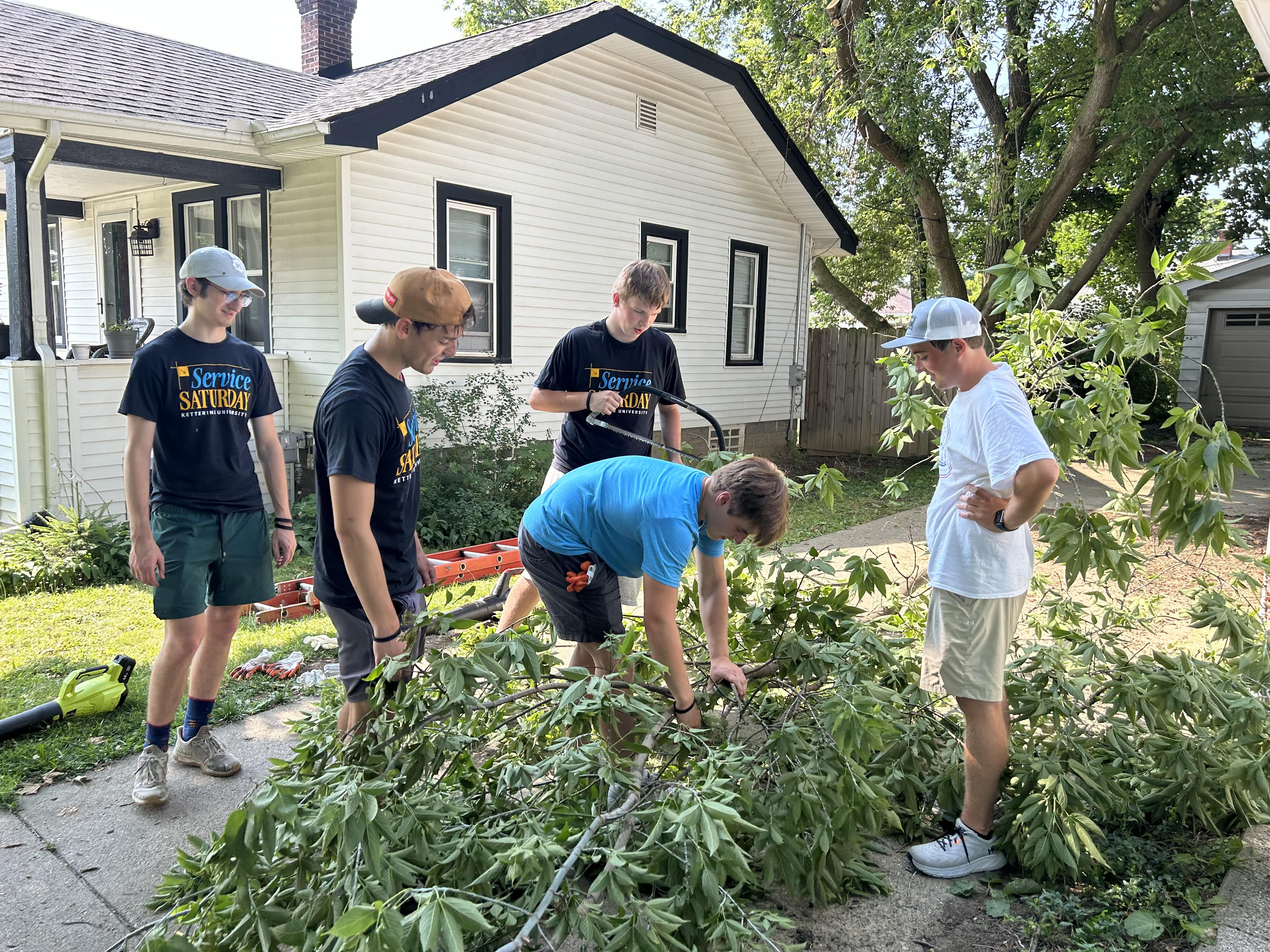 Students cutting down trees on Service Saturday