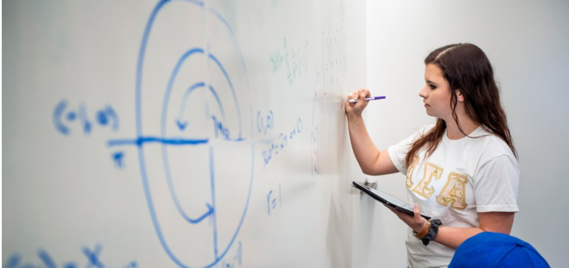 A student works a problem on a whiteboard