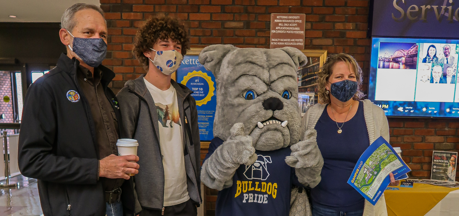 A family tours the campus of Kettering University and is welcomed by the Bulldog.