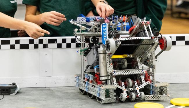 Students collaborate to fine-tune a competition robot at Kettering University's robotics event, showcasing innovative engineering and problem-solving skills.