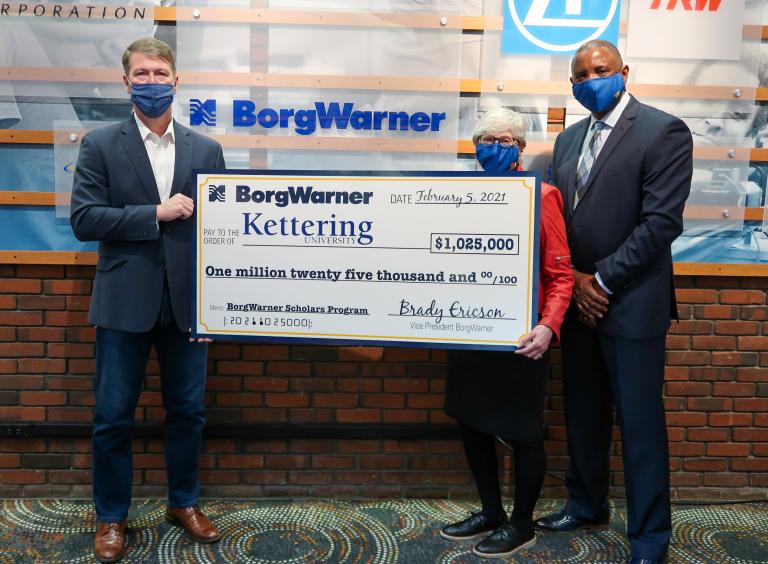 Two men and a woman posing with a large check from BorgWarner to Kettering University for $1,025,000