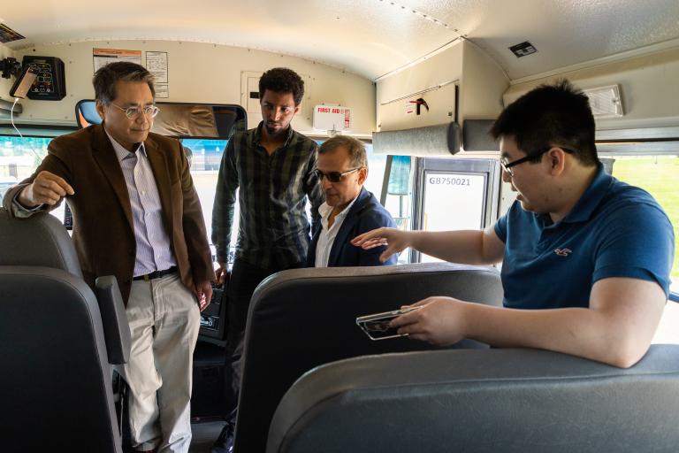 Kettering University students show off their work on a school bus.