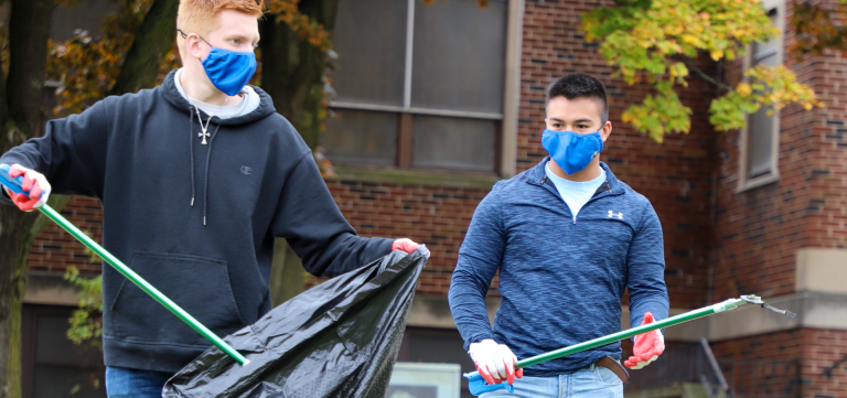 Two Kettering University students clean up trash in Flint.