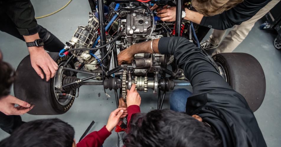 Students work on a competition vehicle in the SAE garage at Kettering University