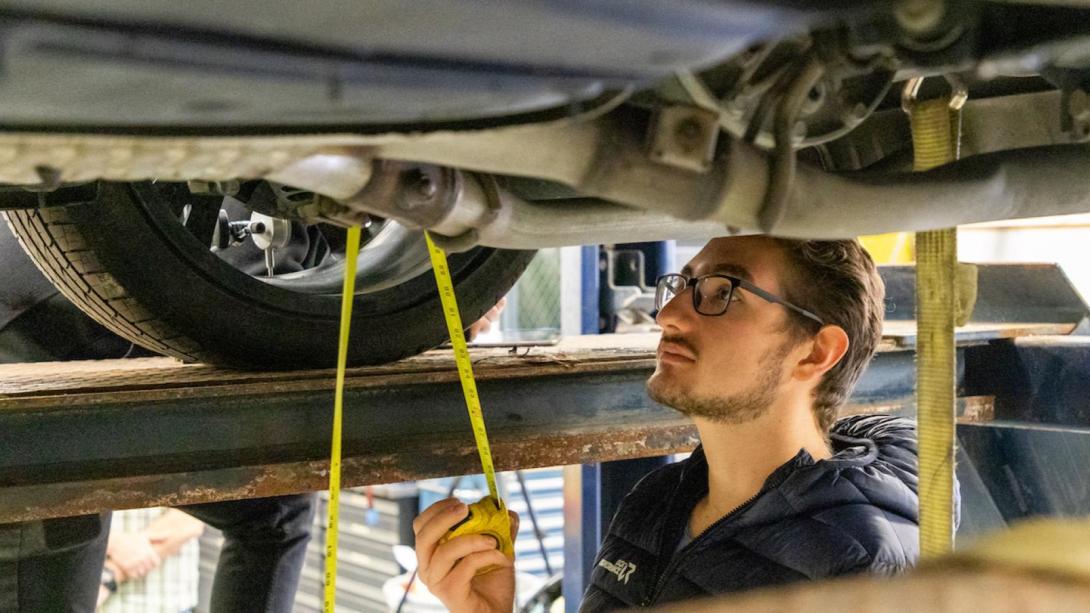 A student working on a car in the SAE garage