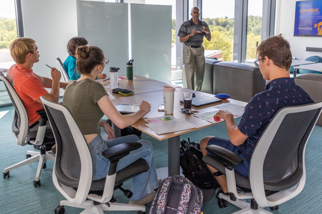 A Professor teaching a class of students in the Learning Commons