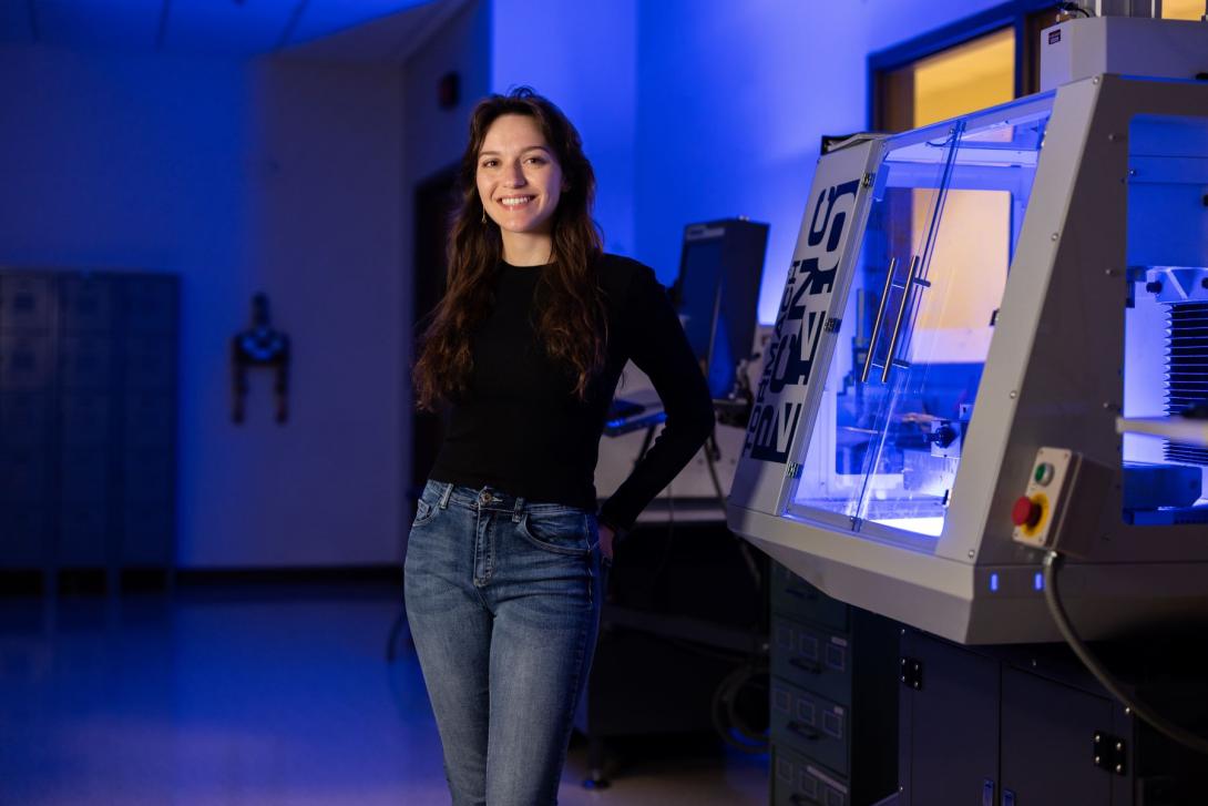 A Kettering student stands next to a CNC mill in the Hougen Design Studio