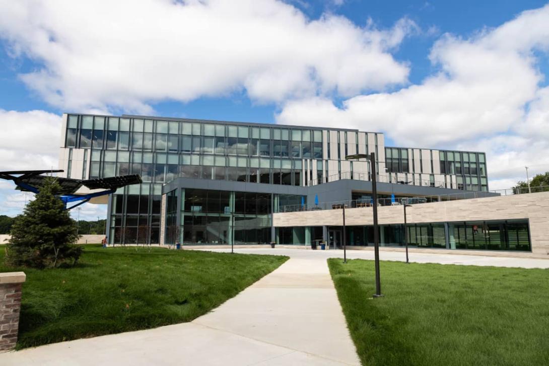 A multi-story glass building on Kettering's campus. In front of the building are grass lawns.