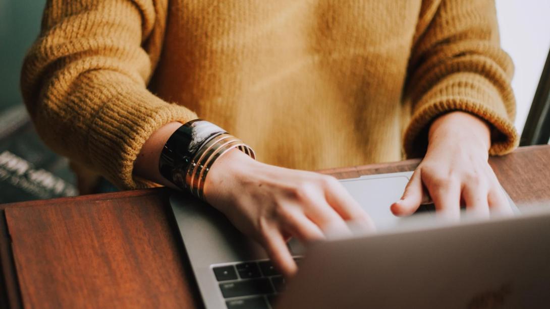 Hands typing on a laptop keyboard