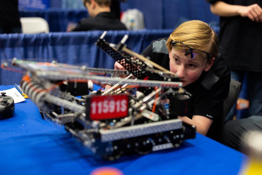 Student examining robot at VEX VRC Championship