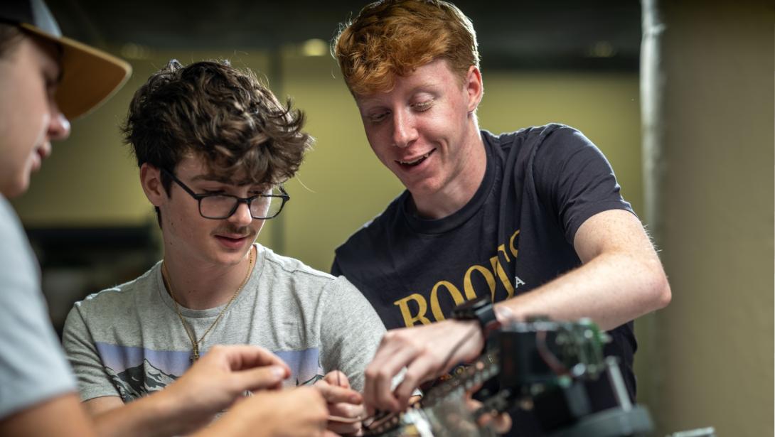 Three students using equipment