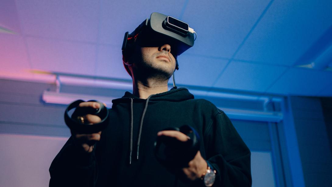 A student using a VR headset and remotes