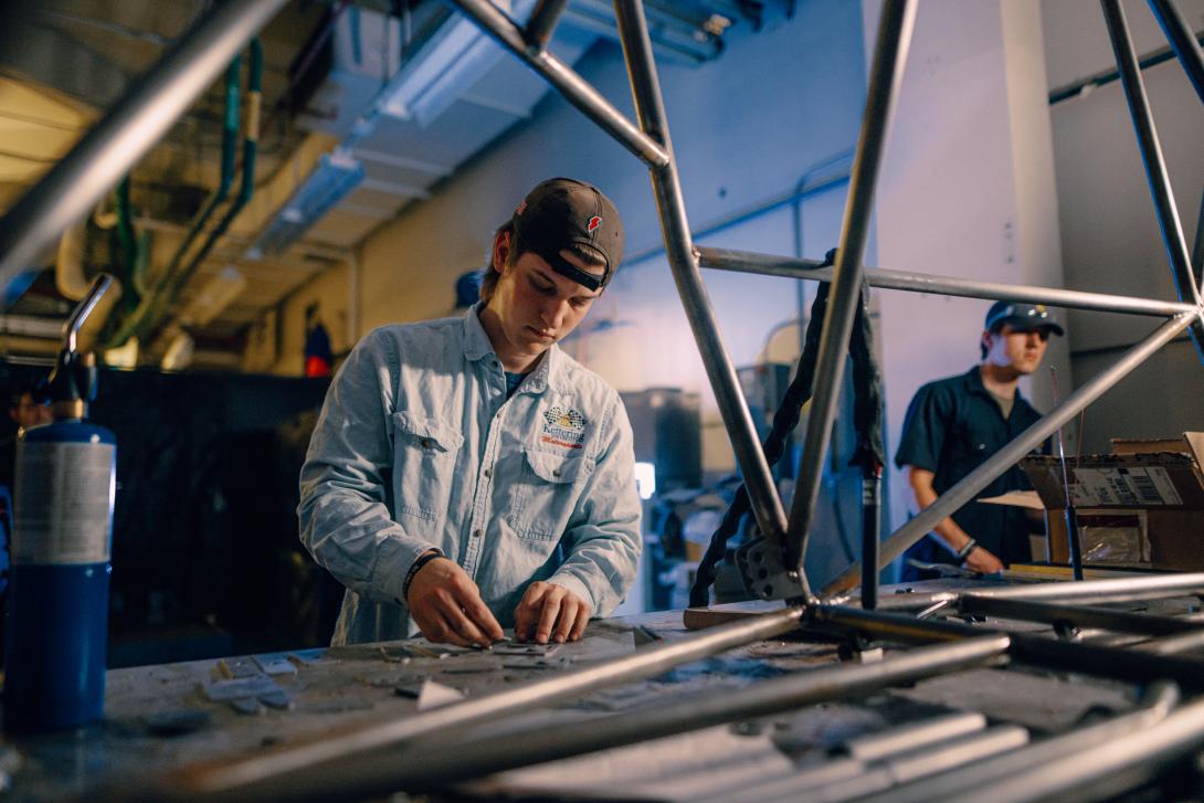 student working on car parts