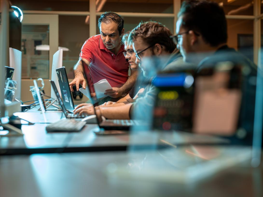 professor helping students on computers